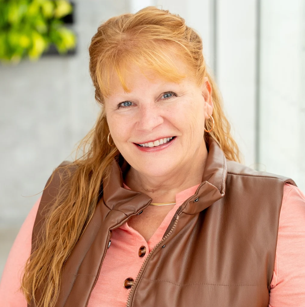 Jeannette Williams, smiling, in a brown vest